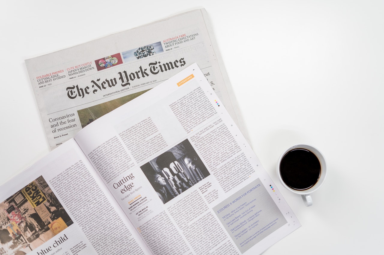 a magazine and newspaper laid flat on a white surface