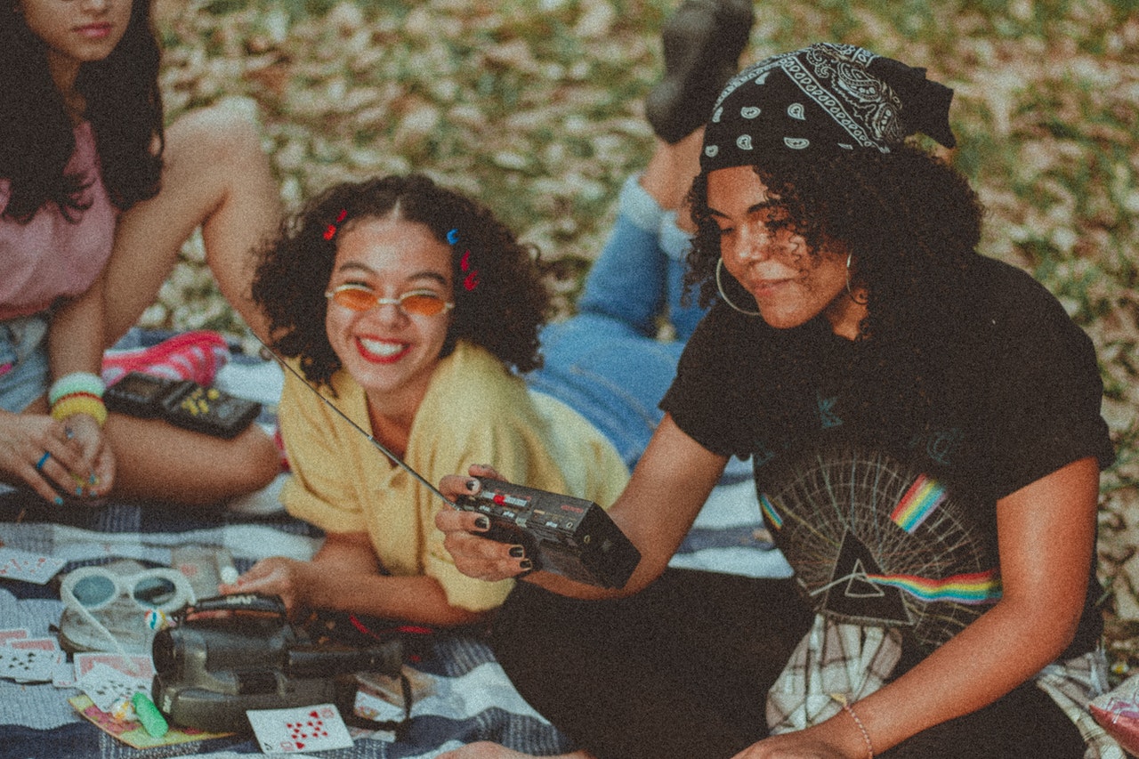 a group of friends using traditional media and the radio to have fun during a picnic