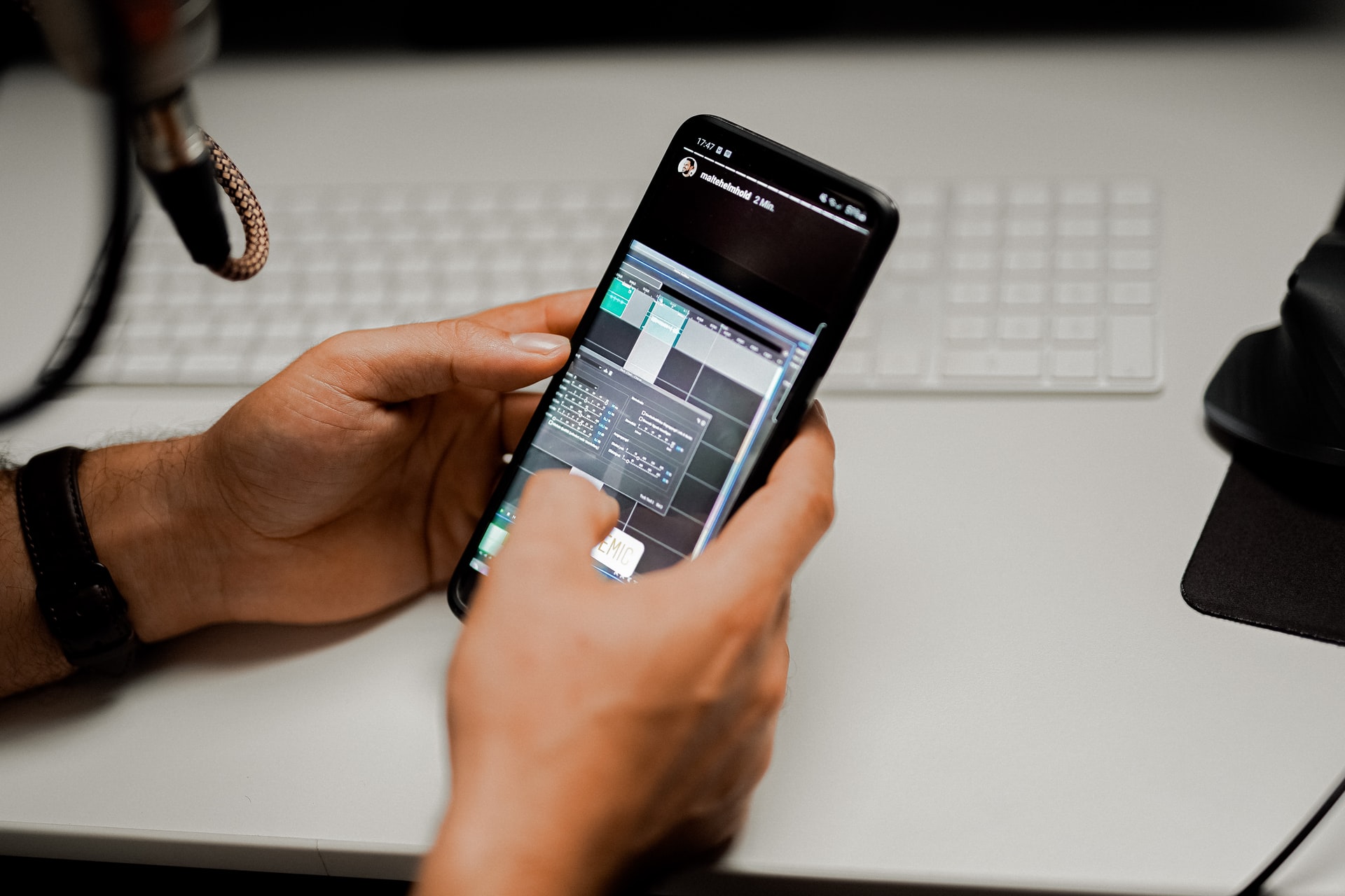Creating an instagram story on the smartphone in front of a keyboard with a microphone