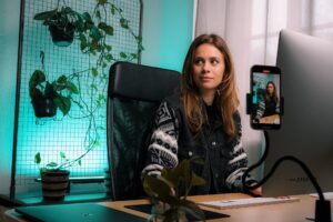 a female content creator working in an office and making videos.