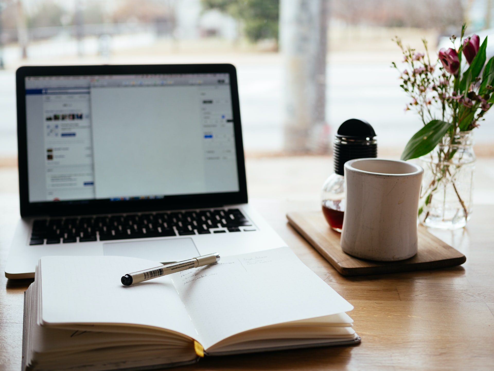 a macbook and notepad on a tabletop
