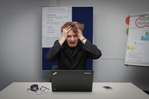 a frustrated man on his black laptop experiencing creative block