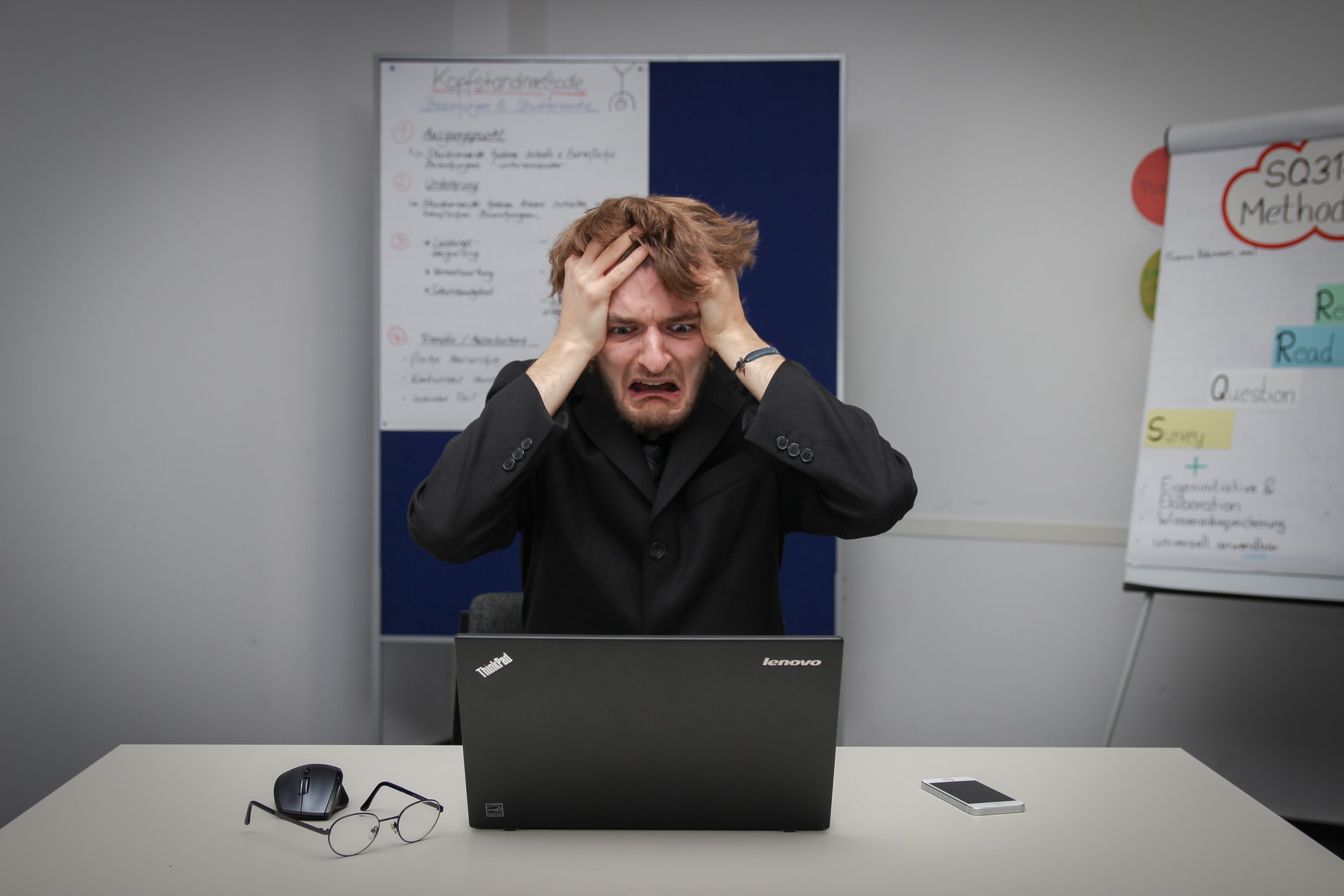 a frustrated man on his black laptop experiencing creative block