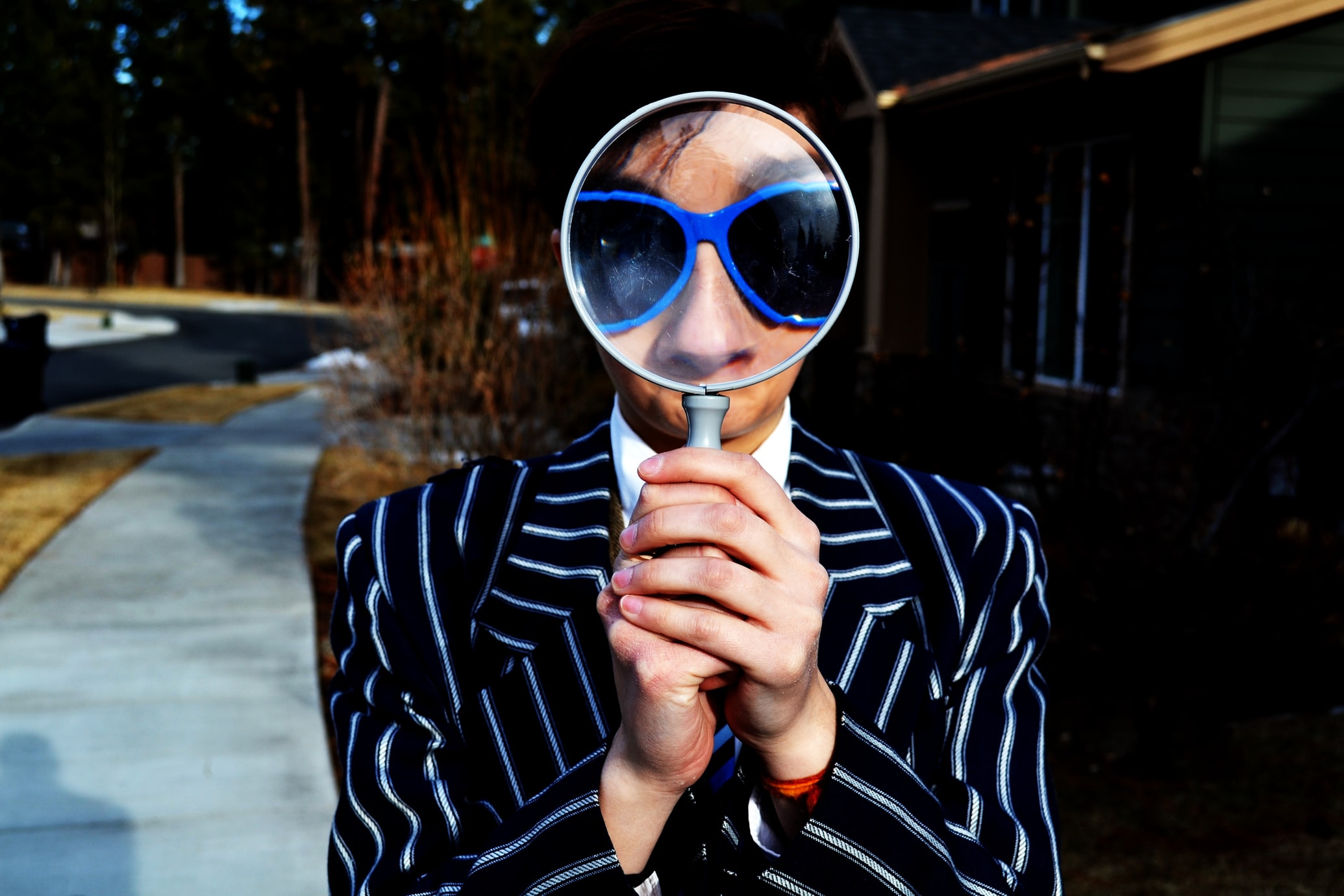a person using a magnifying glass to enlarge the appearance of his sunglasses and nose