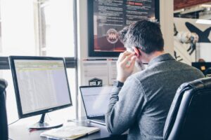 Man performing social listening research on a laptop in an urban office