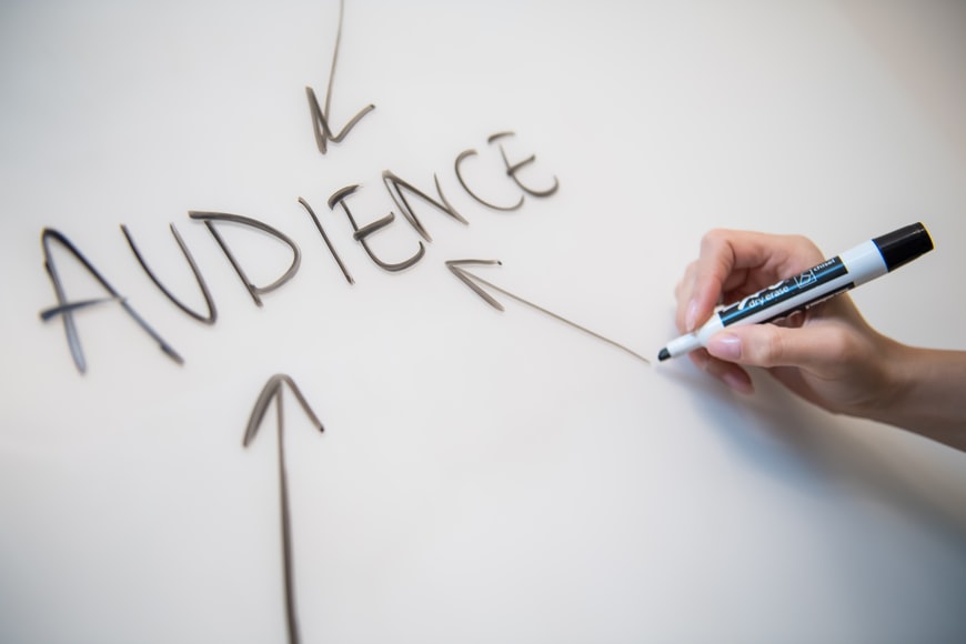 the word “audience” written on a white board