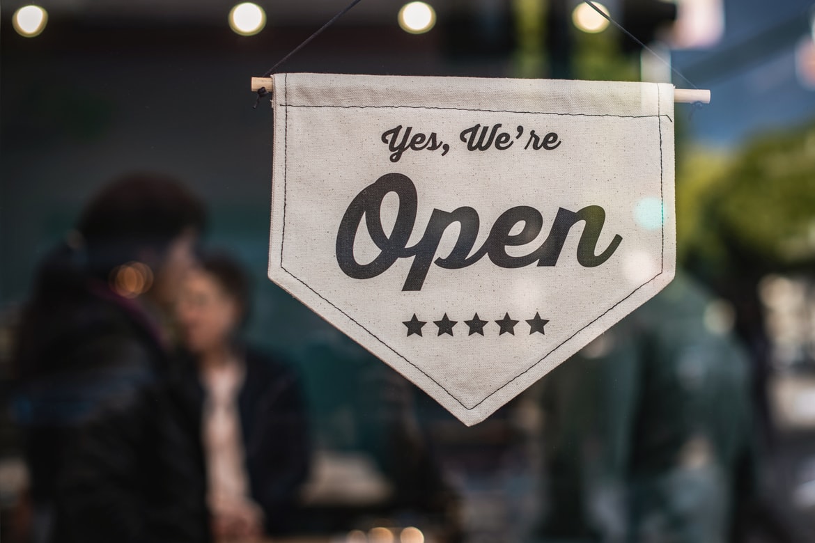  a “we’re open” sign hanging on a storefront