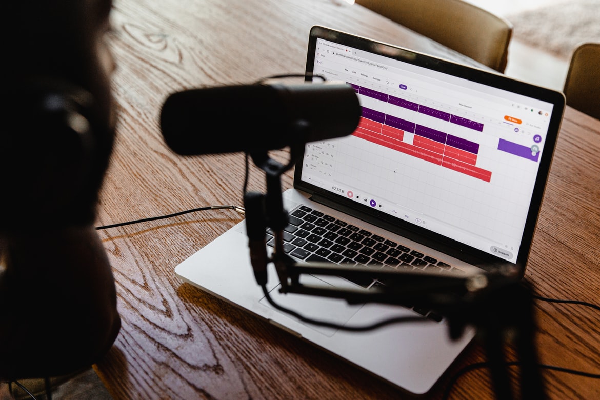 a microphone connected to a macbook pro for podcast recording