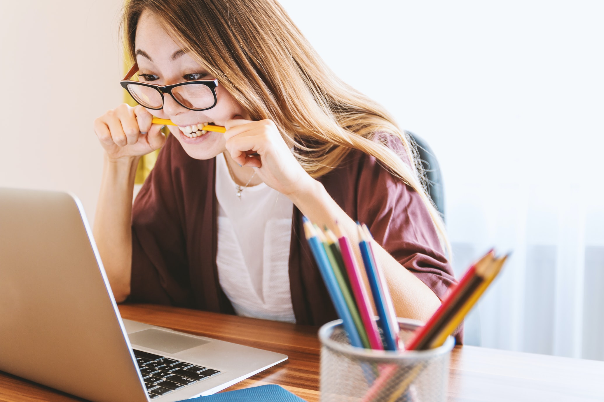 a female content creator biting a pencil in frustration
