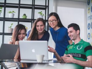 four people watching a viral video on a macbook